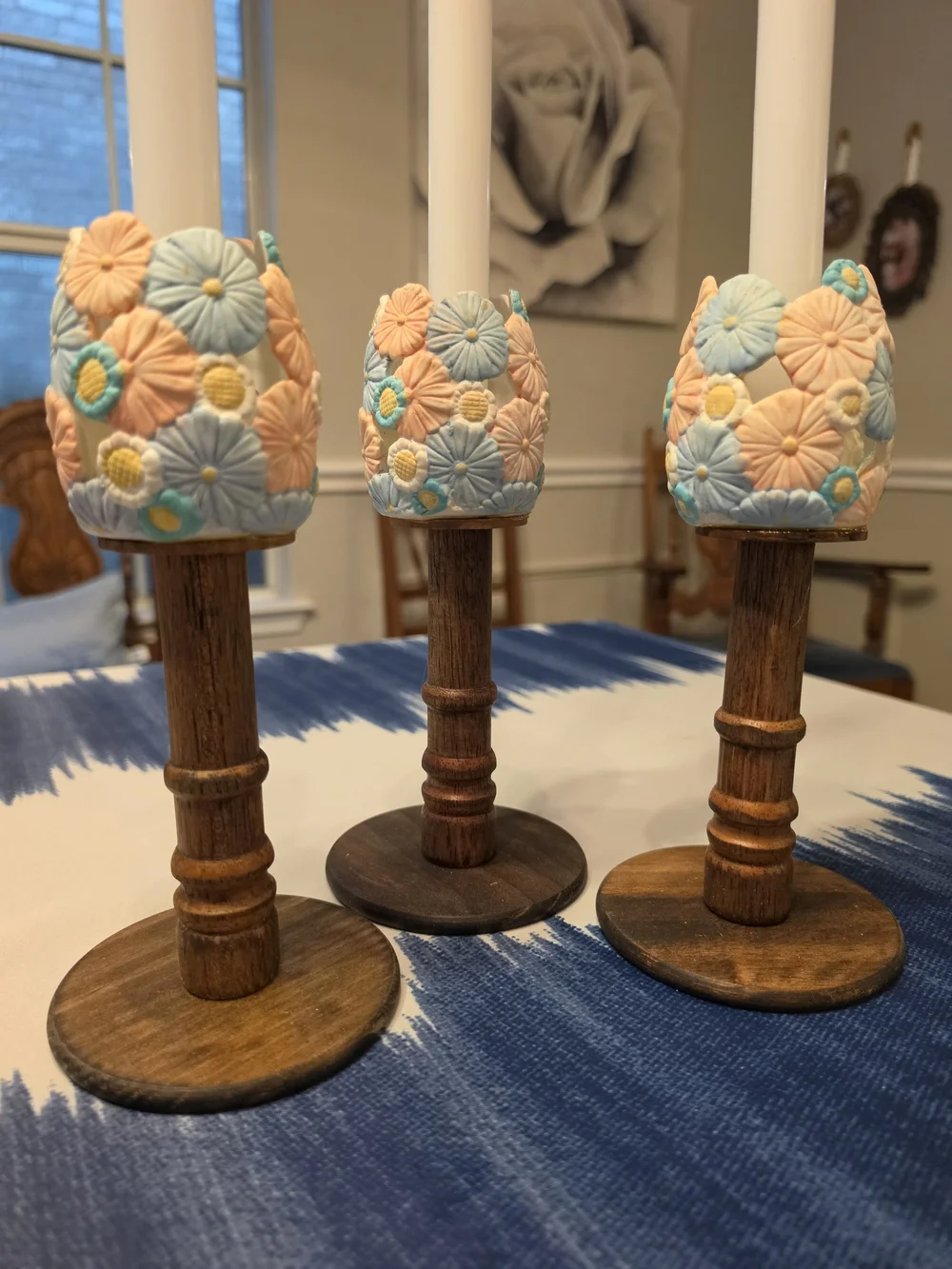 Trio Of Turned dark wood candlestick holders pastel-colored sculpted floral cups